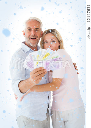 Composite image of happy couple flashing their cash 12147631