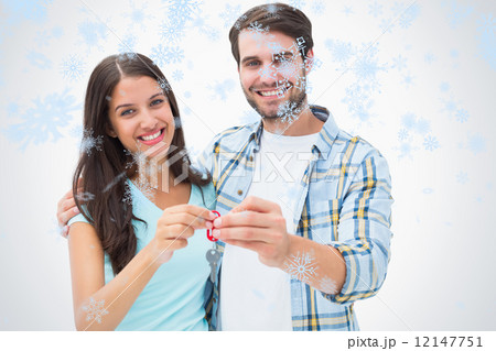 Composite image of happy young couple showing new house key 12147751