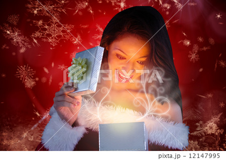 Composite image of sexy santa girl opening gift Composite image of sexy santa girl opening gift 12147995