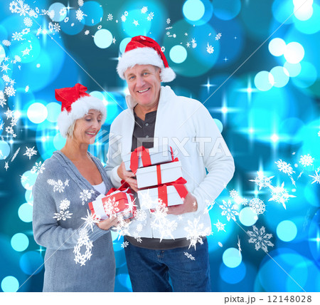 Composite image of festive mature couple holding christmas gifts Composite image of festive mature couple holding christmas gifts 12148028