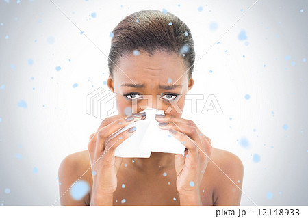 Composite image of worried natural beauty blowing her nose 12148933