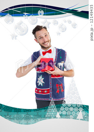 Composite image of geeky hipster offering christmas gift Composite image of geeky hipster offering christmas gift 12149435
