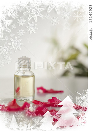 Glass phial and pink petals in a christmas frame 12149923
