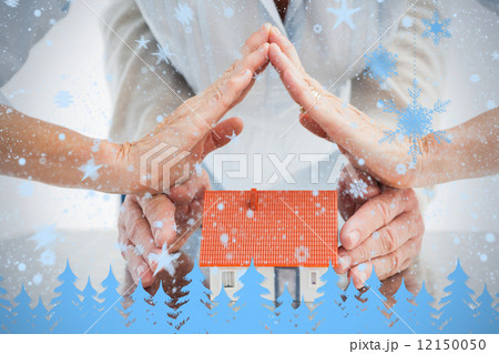 Couples hands with model house 12150050
