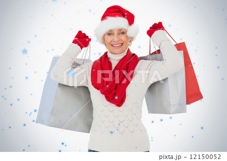 Festive woman smiling at camera holding shopping bags 12150052