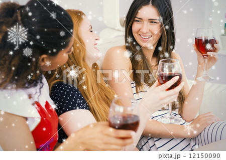 Cheerful friends with wine glasses enjoying a conversation 12150090