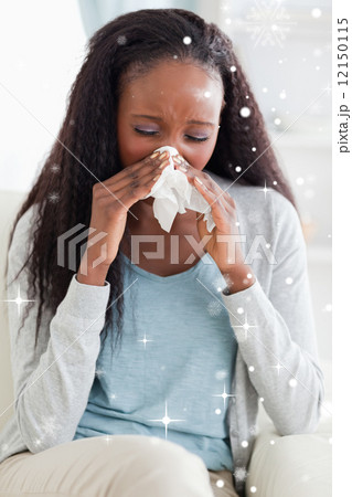 Woman blowing her nose on sofa 12150115