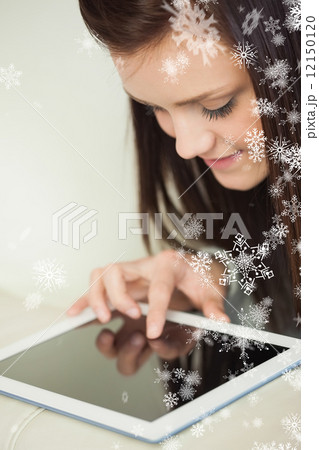 Relaxing girl looking and using a tablet pc on a sofa Relaxing girl looking and using a tablet pc on a sofa 12150120