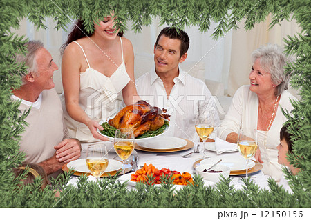Woman showing turkey to her family for christmas dinner 12150156