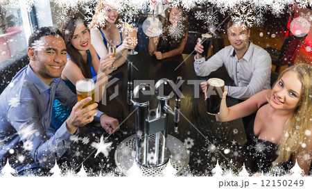 Composite image of young friends sitting together and raising th 12150249