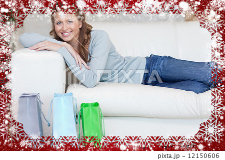 Woman relaxing on the sofa next to her shopping 12150606