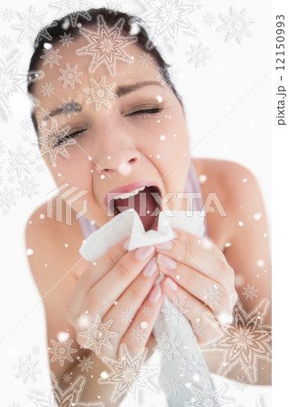 Woman sneezing into a tissue 12150993