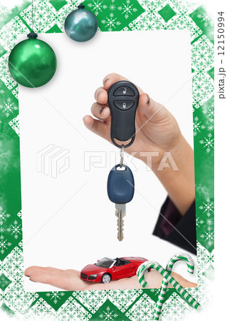 Composite image of woman holding key and small car Composite image of woman holding key and small car 12150994