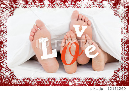 Composite image of pair of feet under duvet with love text Composite image of pair of feet under duvet with love text 12151260