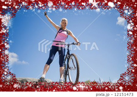 Fit pretty cyclist on a rocky terrain smiling at camera 12151473