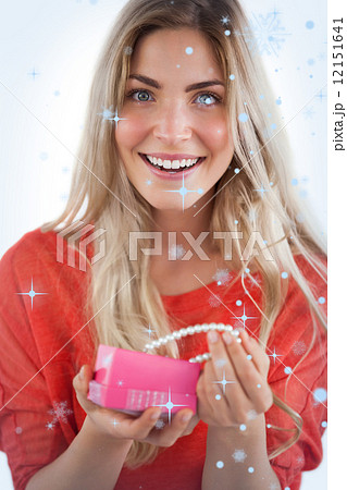 Composite image of cheerful woman discovering necklace in a gift box Composite image of cheerful woman discovering necklace in a gift box 12151641