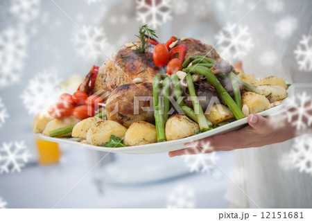 Composite image of woman presenting a roast dinner 12151681