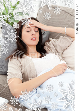Sck woman lying on the sofa and touching her forehead 12151952