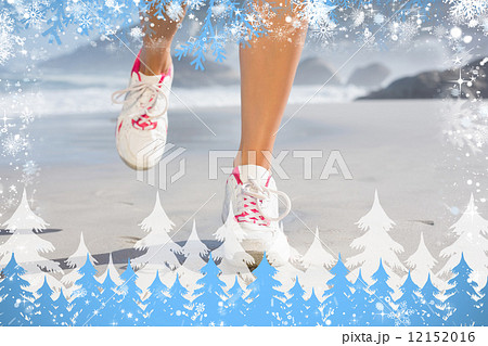 Composite image of fit woman walking on the beach 12152016