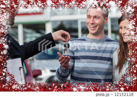 Composite image of couple receiving car keys by a dealer 12152116