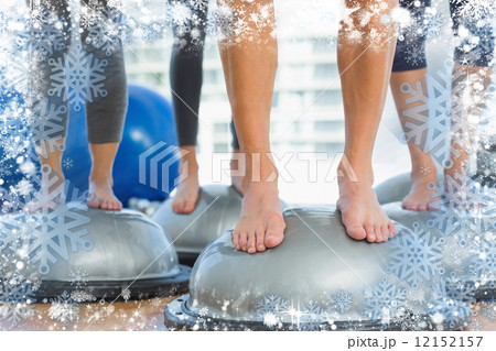 Low section of fit people standing on exercise equipment 12152157