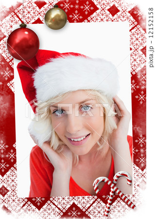 Young blonde woman putting on the santa claus hat 12152158