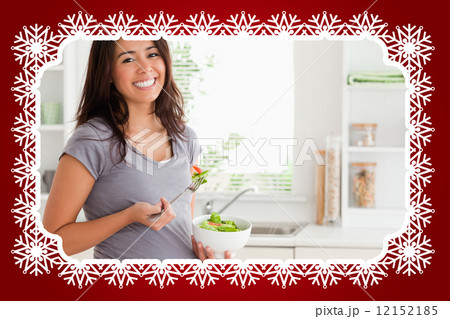 Attractive pregnant woman holding a bowl of salad while standing 12152185