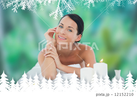 Beautiful brunette relaxing on massage table smiling at camera Beautiful brunette relaxing on massage table smiling at camera 12152210