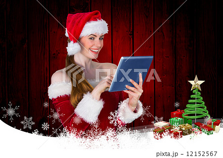 Composite image of pretty santa girl using tablet pc Composite image of pretty santa girl using tablet pc 12152567