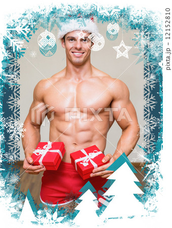Composite image of shirtless macho man in santa hat holding gift Composite image of shirtless macho man in santa hat holding gift 12152810
