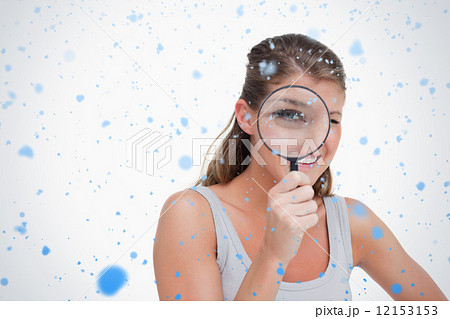 Woman looking through a magnifying glass Woman looking through a magnifying glass 12153153