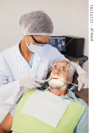 Dentist examining a patients teeth in the dentists chair Dentist examining a patients teeth in the dentists chair 12153781