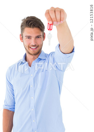 Handsome young man showing new house key Handsome young man showing new house key 12153816