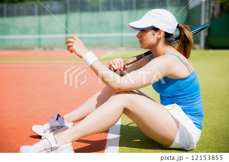 Pretty tennis player sitting on court Pretty tennis player sitting on court 12153855