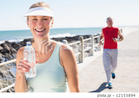 Fit mature couple jogging together on the pier 12153894