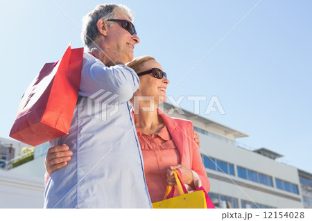 Happy senior couple holding shopping bags 12154028