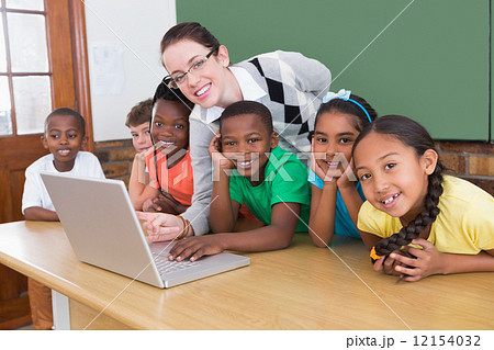 Teacher and pupils working at laptop 12154032