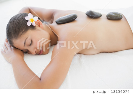 Beautiful brunette enjoying a hot stone massage Beautiful brunette enjoying a hot stone massage 12154074