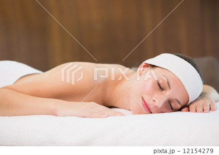 Beautiful woman lying on massage table at spa center 12154279