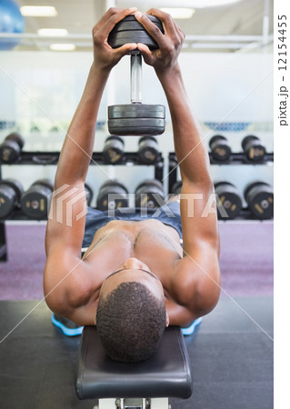 Shirtless man exercising with dumbbell in gym Shirtless man exercising with dumbbell in gym 12154455