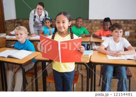 Cute pupils smiling at camera in classroom 12154491