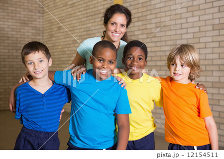 Cute pupils smiling at camera with PE teacher 12154511