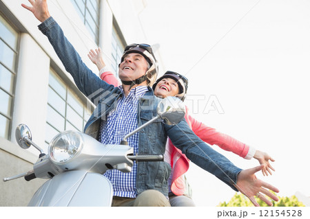 Happy senior couple riding a moped 12154528