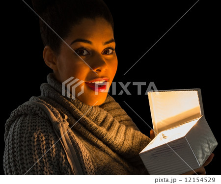 Pretty girl opening a glowing gift 12154529