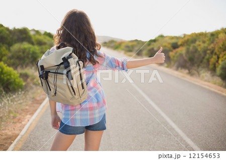 Woman hitchhiking on countryside road Woman hitchhiking on countryside road 12154653
