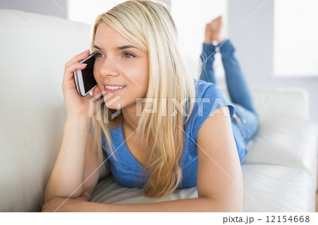 Relaxed beautiful woman using mobile phone in living room Relaxed beautiful woman using mobile phone in living room 12154668