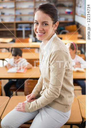 Pretty teacher smiling at camera at top of classroom 12154734