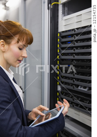 Pretty technician using tablet pc while working on servers 12154735