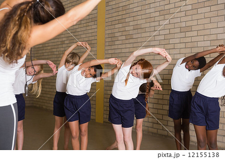 Cute pupils warming up in PE uniform Cute pupils warming up in PE uniform 12155138