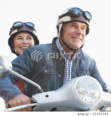 Happy senior couple riding a moped 12155242